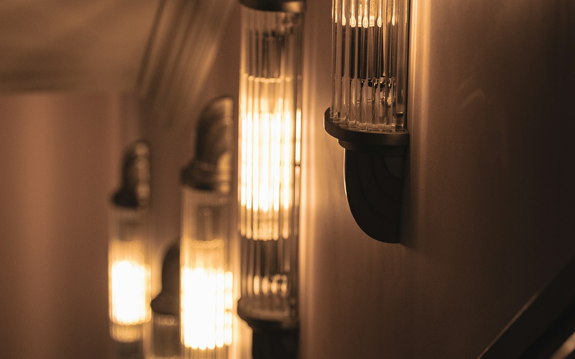 Warm wall sconces lighting a dark hallway, creating a visible path through the interior at night